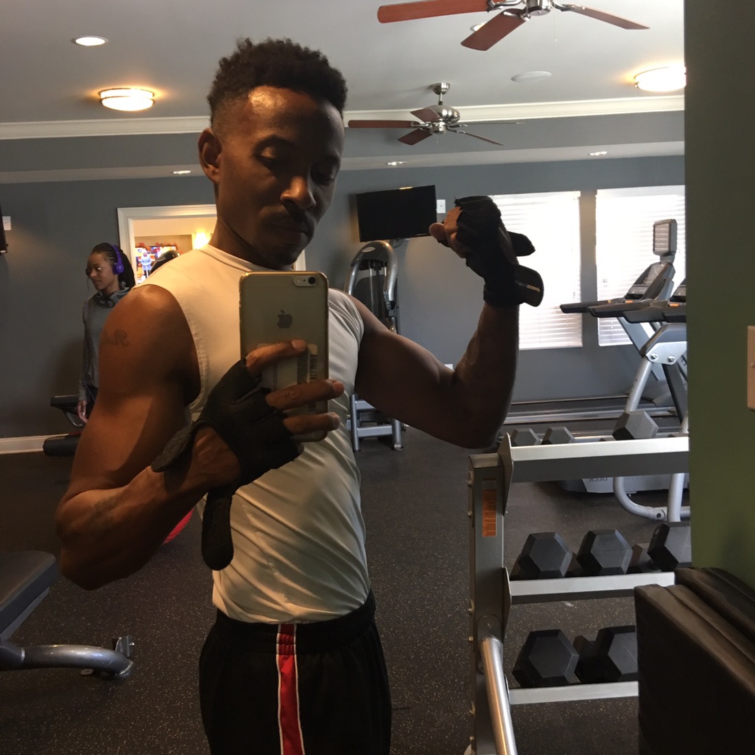 Richbz in the mirror trying to flex at the gym